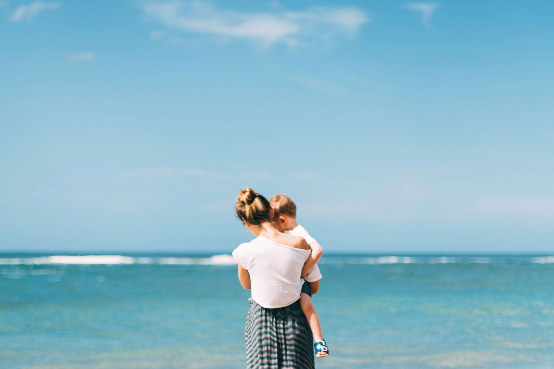 single mother with her baby on the beach